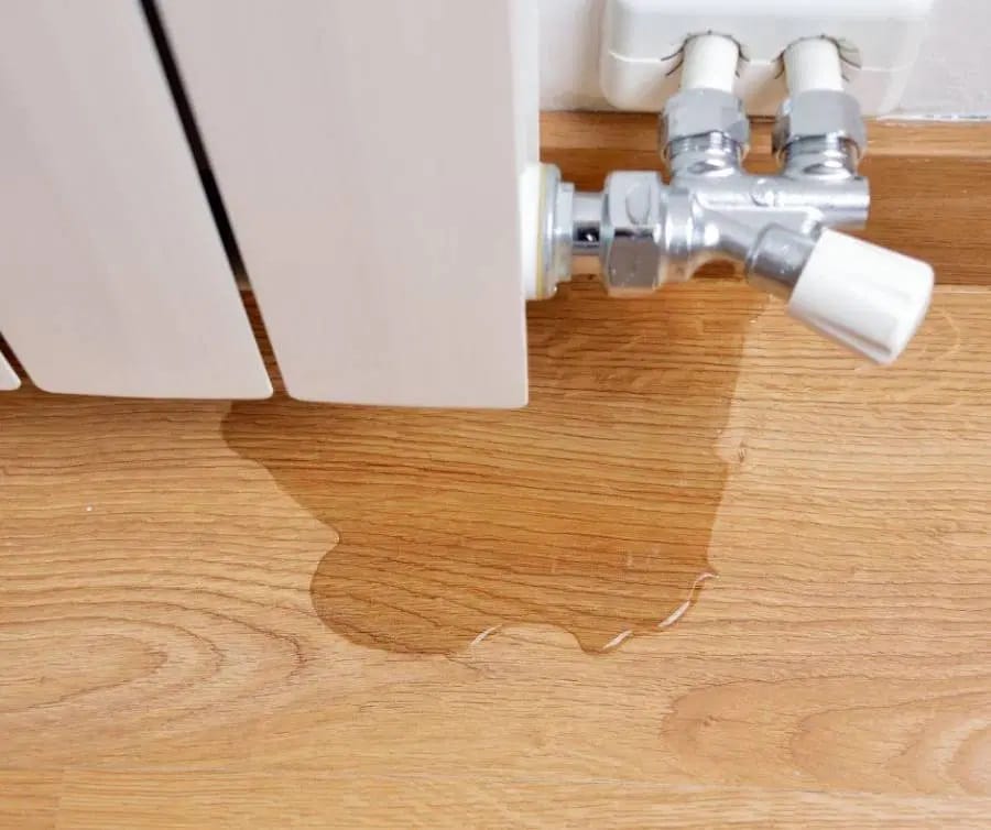 Wasser tropft aus einem Heizkörperventil