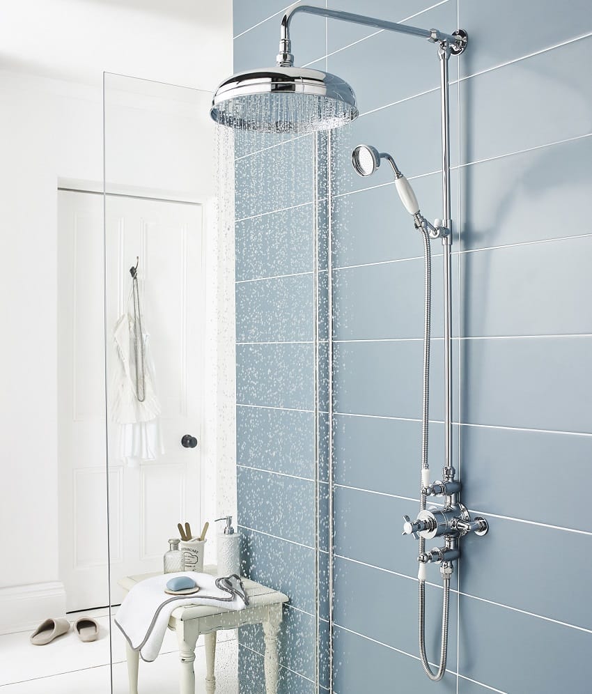 Moderne Duschkabine mit Regendusche und blauen Wandfliesen Offene Dusche mit runder Regendusche, Handbrause und blauen rechteckigen Wandfliesen in einem stilvoll eingerichteten Badezimmer.